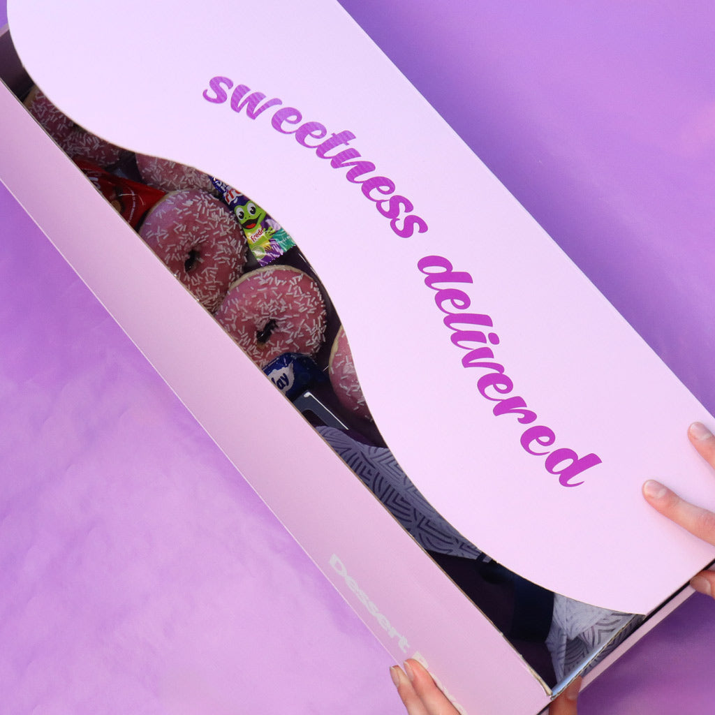 Box of donuts with 'sweetness delivered' text on a purple background