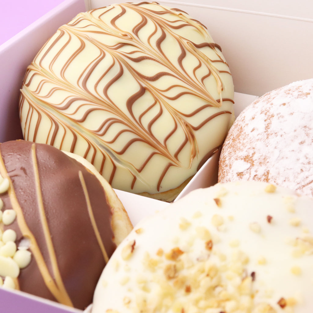 Assorted donuts with different toppings in a box.
