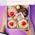 Box of assorted donuts with Nutella spread on a purple background