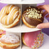 Assorted donuts on a tiered stand with a hand picking up a chocolate donut with white sprinkles.