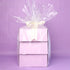 Stack of purple gift boxes with cellophane and a bow on a purple background