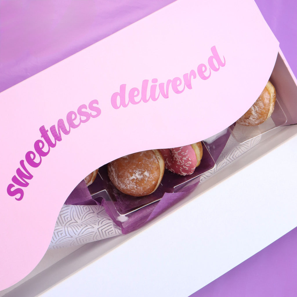 Box of donuts with 'sweetness delivered' text on a purple background