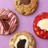 Four cookies with different flavors on a purple background