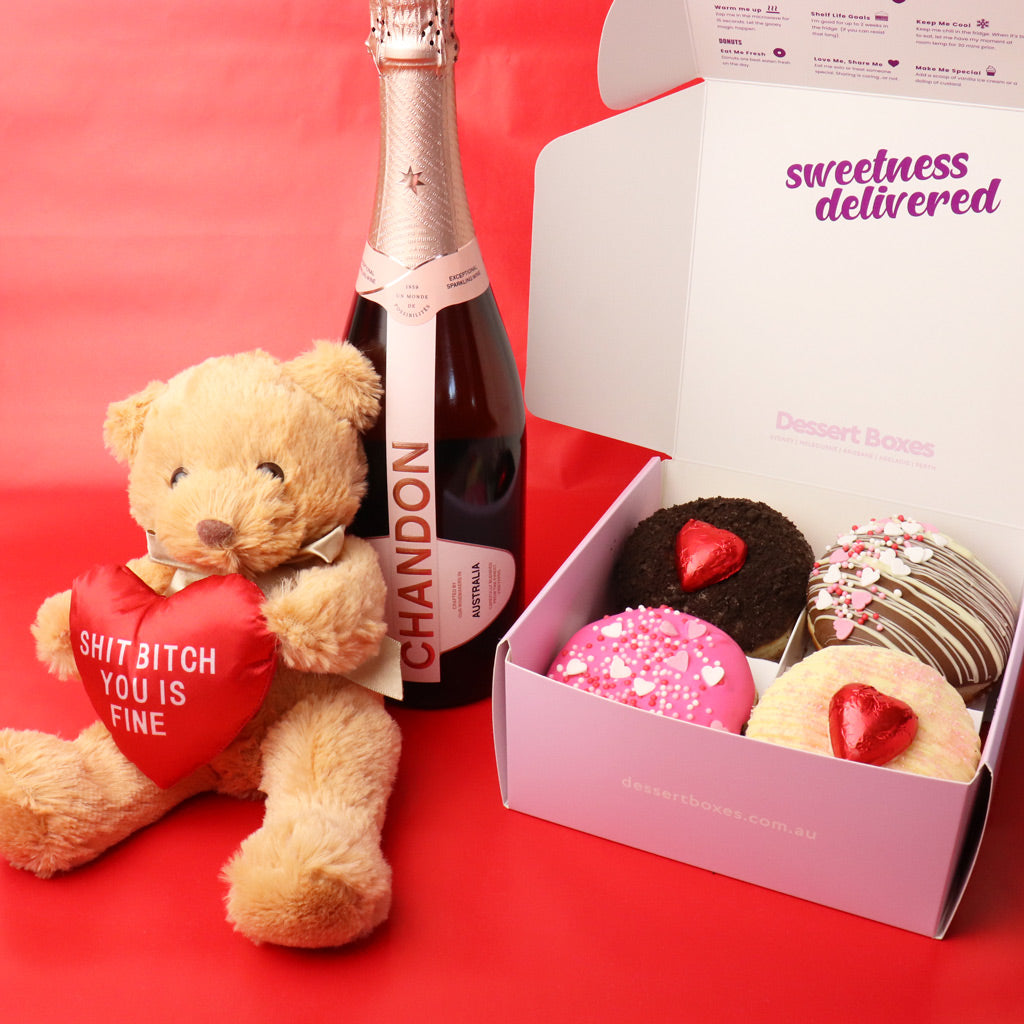 Teddy bear with a heart-shaped pillow, bottle of Chandon champagne